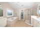 Well-lit bathroom featuring a soaking tub, glass-enclosed shower, and vanity with countertop space at 106 Roundtop Rd, Cary, NC 27519