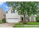 Traditional two-story home with white siding, a two-car garage, front porch, and a manicured lawn at 106 Roundtop Rd, Cary, NC 27519