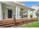 Inviting front porch with brick accents, elegant railings, and decorative hanging plants at 106 Roundtop Rd, Cary, NC 27519