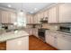 Well-lit kitchen featuring granite countertops, stainless steel appliances, and ample cabinet space at 106 Roundtop Rd, Cary, NC 27519