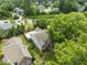 Aerial view showcasing the property surrounded by lush trees, a green lawn, and neighboring homes at 107 Covington Dr, Chapel Hill, NC 27514