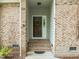 Inviting front entry with brick accents, steps leading to door, and a decorative wreath at 107 Covington Dr, Chapel Hill, NC 27514