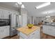 View of kitchen with stainless steel refrigerator, island, and view of the living room with fireplace at 107 Covington Dr, Chapel Hill, NC 27514
