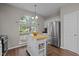 Bright kitchen with an island, stainless steel appliances, white cabinets, and a large arched window at 107 Covington Dr, Chapel Hill, NC 27514