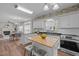 Open concept kitchen with center island, stainless steel appliances and a view into the dining room at 107 Covington Dr, Chapel Hill, NC 27514