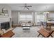 Bright living room featuring a fireplace, ceiling fan, and large windows dressed with white curtains at 107 Covington Dr, Chapel Hill, NC 27514
