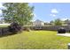 Large, fenced backyard with lush lawn, mature trees, and playset, perfect for outdoor enjoyment at 110 Bray Dr, Mebane, NC 27302
