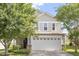Charming two-story home with neutral siding and a two car garage, framed by mature trees in the front yard at 110 Bray Dr, Mebane, NC 27302