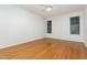 Neutral bedroom has hardwood floors and multiple windows with mini blinds at 11005 Louson Pl, Raleigh, NC 27614