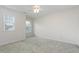 Bright bedroom with neutral carpet, ceiling fan, and natural light from large windows at 11005 Louson Pl, Raleigh, NC 27614