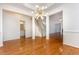 Open dining room featuring modern lighting, hardwood floors, crown molding, and access to other living spaces at 11005 Louson Pl, Raleigh, NC 27614