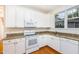 Well-lit kitchen featuring white cabinets, granite countertops, and stainless steel appliances at 11005 Louson Pl, Raleigh, NC 27614