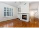 Living room with vaulted ceiling, ceiling fan, hardwood floors, fireplace, and large window with shutters at 11005 Louson Pl, Raleigh, NC 27614
