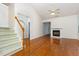 Bright living room with hardwood floors, fireplace, vaulted ceiling, and staircase to the second level at 11005 Louson Pl, Raleigh, NC 27614
