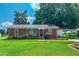 Charming brick home with metal roof, lush landscaping and a convenient carport at 111 Dee Long Rd, Roxboro, NC 27574