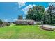 Charming brick home features lush lawn, mature trees and attached carport at 111 Dee Long Rd, Roxboro, NC 27574