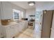 Kitchen boasts white cabinets, stainless steel appliances, and tile countertops at 111 Dee Long Rd, Roxboro, NC 27574