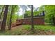 Brick home featuring a back deck amid lush greenery, offering peaceful seclusion at 1116 Little Creek Rd, Durham, NC 27713