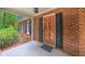 Inviting covered porch with brick accents, complemented by a red door and black shutters for a classic look at 1116 Little Creek Rd, Durham, NC 27713