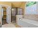 A luxurious bathroom featuring a shower, soaking tub, tile flooring, and a large arched window at 1124 Kalworth Rd, Wake Forest, NC 27587