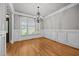 Dining room features hardwood floors, a chandelier, and classic wainscoting at 1124 Kalworth Rd, Wake Forest, NC 27587