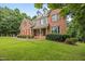 Beautiful brick home with red shutters, mature trees, and lush green lawn at 1124 Kalworth Rd, Wake Forest, NC 27587
