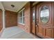 Inviting front porch with decorative glass front door and brick columns at 1124 Kalworth Rd, Wake Forest, NC 27587