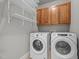 Functional laundry room with a washer, dryer, storage cabinets, and wire rack shelving at 1124 Kalworth Rd, Wake Forest, NC 27587