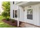 Charming entrance featuring a white front door with glass and siding, with manicured landscaping and mulched beds at 118 Rhum Pl, Garner, NC 27529