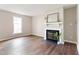 Cozy living room boasts a fireplace and hardwood floors; filled with natural light from a large window at 118 Rhum Pl, Garner, NC 27529