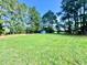 Large backyard with well-manicured lawn and shed surrounded by tall pine trees at 1283 Ennis Rd, Angier, NC 27501