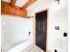 Bathroom featuring a white bathtub, black fixtures, wood trim, and white panel walls at 1283 Ennis Rd, Angier, NC 27501