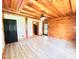 A bedroom that features exposed wood ceiling beams, walls, wood flooring, and a ceiling fan for comfort at 1283 Ennis Rd, Angier, NC 27501