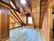An attic bedroom has wood beams, wood walls, and light-colored flooring at 1283 Ennis Rd, Angier, NC 27501