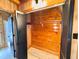 Closet with wood paneling, wood flooring, shelving, and black shutter doors offers ample storage at 1283 Ennis Rd, Angier, NC 27501