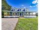 Charming blue home with a wide, inviting wrap-around porch and well-maintained lawn at 1283 Ennis Rd, Angier, NC 27501