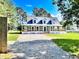 Beautiful blue home featuring a spacious wrap-around porch and a gravel driveway at 1283 Ennis Rd, Angier, NC 27501