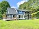 Two-story home with blue siding, multiple decks, well-maintained lawn and mature trees providing shade at 1283 Ennis Rd, Angier, NC 27501