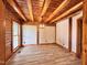 A spacious living room featuring exposed wood beams, white walls, wood flooring, and a modern light fixture at 1283 Ennis Rd, Angier, NC 27501