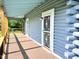 View of the front porch with log siding and a white decorative front door at 1283 Ennis Rd, Angier, NC 27501