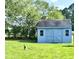 A blue shed with double doors, and two windows, sits on a large well-manicured lawn at 1283 Ennis Rd, Angier, NC 27501