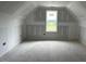 Unfinished attic space with a window providing natural light, ready for customization and personalization at 129 Retreat Run, Smithfield, NC 27577