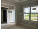 Bright room featuring a large window providing lots of natural light, wainscoting, and an open doorway at 129 Retreat Run, Smithfield, NC 27577