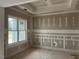 Well-lit room with wainscoting on the bottom half of the walls, trim and a large window at 129 Retreat Run, Smithfield, NC 27577