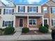 Inviting townhome featuring a brick facade, black shutters, and well-maintained landscaping at 1304 Cozart St # 119, Durham, NC 27704
