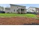 View of a spacious backyard with a screened porch and well-maintained landscaping and a pine straw covered area at 1324 Sandybrook Ln, Wake Forest, NC 27587