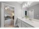 This bathroom features double sinks and white cabinets with doors leading to bedroom at 1324 Sandybrook Ln, Wake Forest, NC 27587