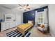 This bedroom features blue accent wall with a single bed, white dresser, and sitting area at 1324 Sandybrook Ln, Wake Forest, NC 27587