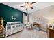 This Bedroom features a white crib, green accent wall and a small rocking chair at 1324 Sandybrook Ln, Wake Forest, NC 27587