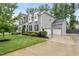 Two-story gray home showcasing a three car garage and long driveway at 1324 Sandybrook Ln, Wake Forest, NC 27587